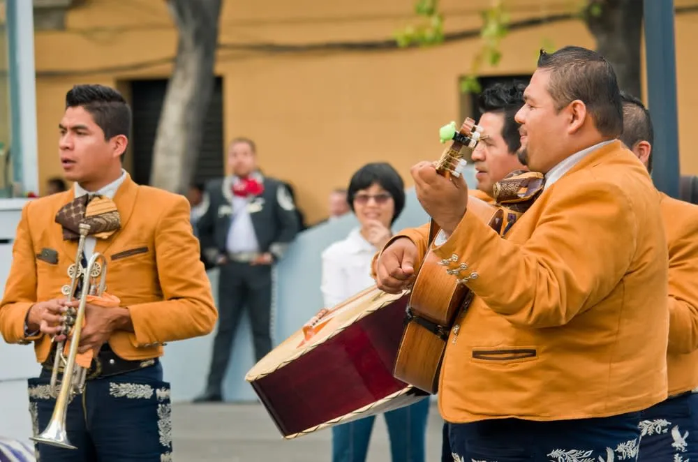 Mariachi musicians and visitors in Garibaldi Square at night