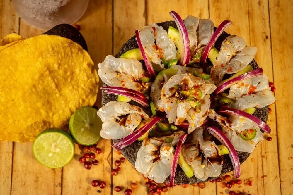 Prepared aguachile ingredients with shrimp, lime, cucumber, onion, cilantro, and chiles