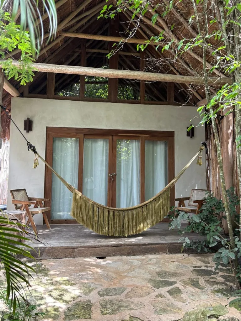 Rustic Tulum jungle cabin with wood walls and tropical plants