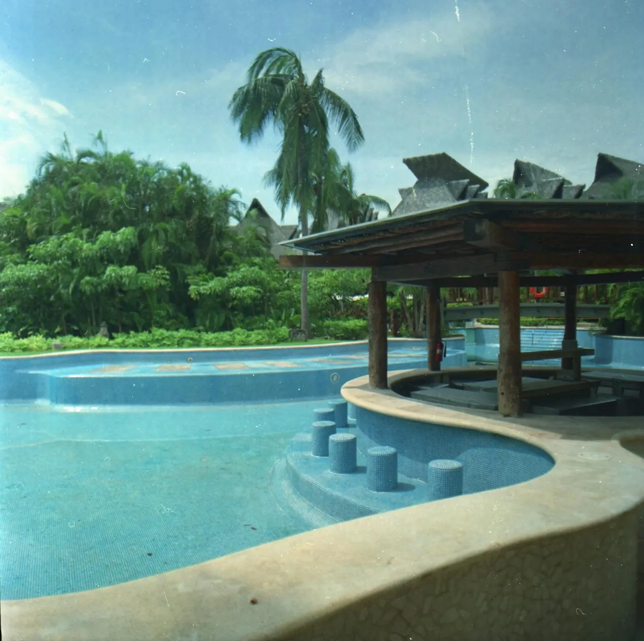 Swim-up bar at a Cancun all-inclusive resort with guests enjoying the Caribbean backdrop