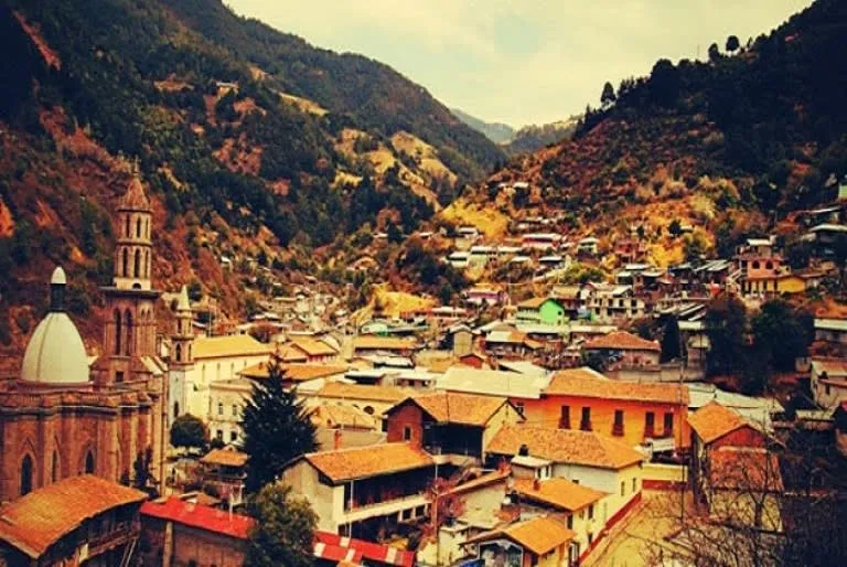 Hillside street and old mining buildings in Angangueo