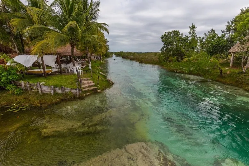 Quiet Bacalar dock facing layered blue lagoon water near sunset