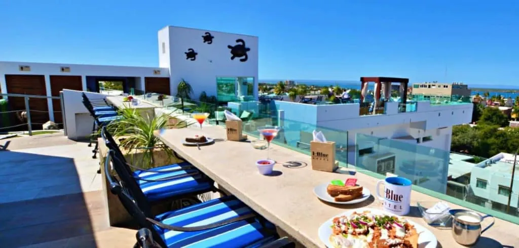 Rooftop pool terrace with lounge chairs facing the sea