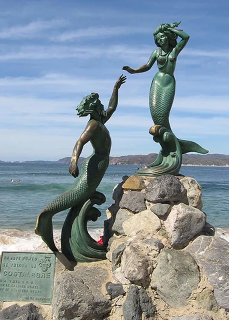 Malecon of Barra de Navidad at dusk — waterfront promenade with the Grand Bay Hotel visible across the lagoon