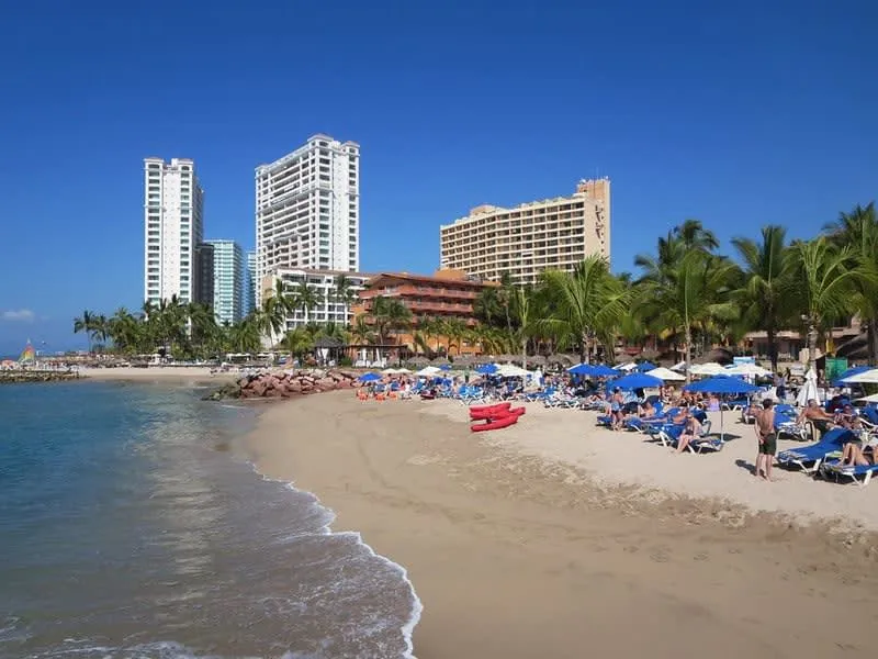 Wide Los Tules beach in Puerto Vallarta beside hotel-zone palms