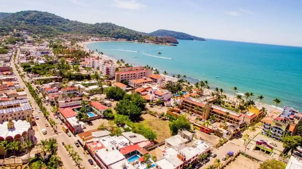Calm Rincon de Guayabitos bay with palapas and anchored boats