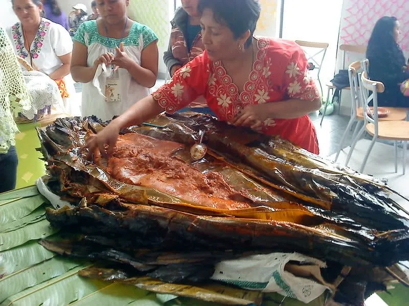 Large zacahuil tamale unwrapped with red chile masa and pork