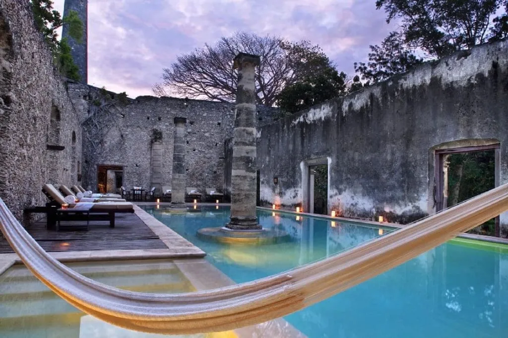 Hacienda Uayamon spa treatment space framed by tropical greenery and restored stone walls