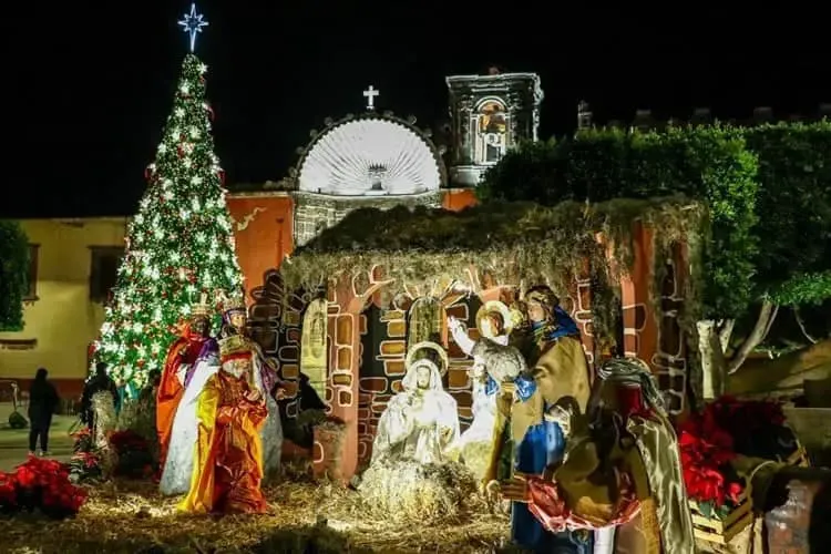 Christmas Las Posadas celebration in San Miguel de Allende at night with candles and colonial facades lit up during the holiday season