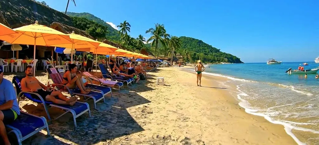 Open-air seafood tables and umbrellas on the sand at Las Animas