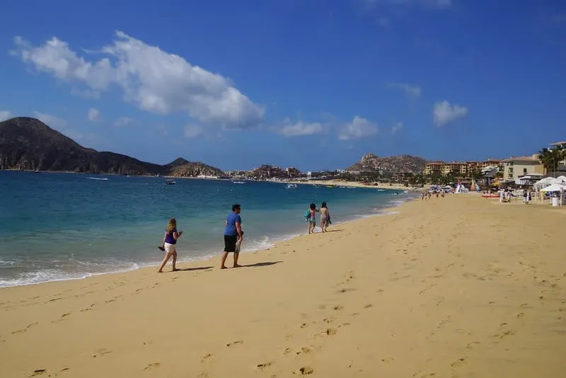 Médano Beach in Cabo San Lucas with boats, beach clubs, and the Sea of Cortez