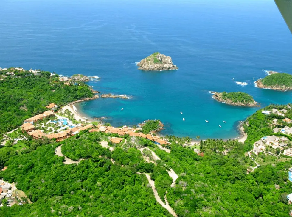 Careyes cove with emerald water and villas above the rocky coast