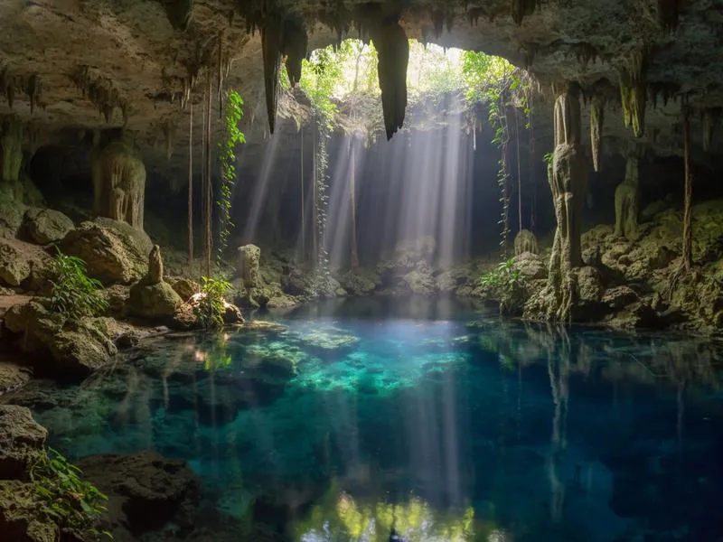 Light beams entering a cenote cave system near Tulum, Mexico