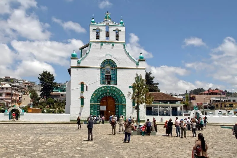 San Juan Bautista church exterior — whitewashed colonial facade with colorful flower decorations before a ceremony in San Juan Chamula