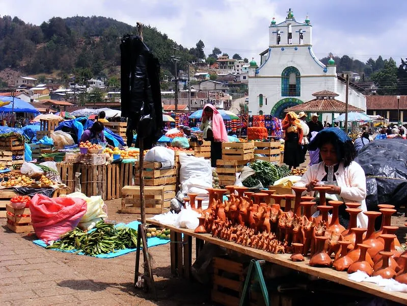 Traditional Tzotzil market at San Juan Chamula with vendors selling textiles and religious items