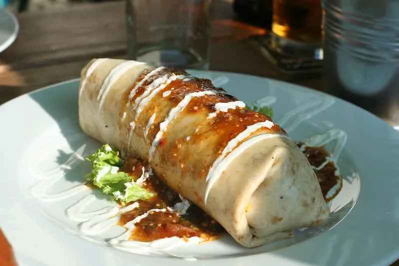 Fried chimichanga beside a soft flour tortilla burrito