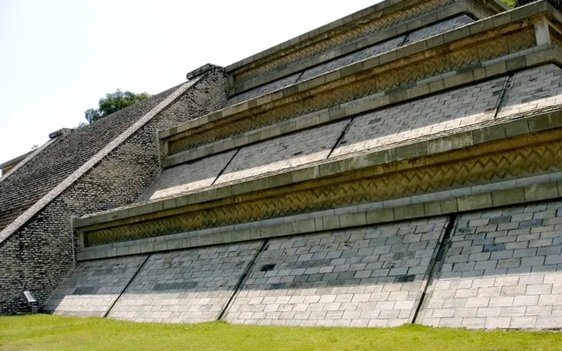 Green Cholula pyramid mound with the hilltop church and Puebla Valley behind it