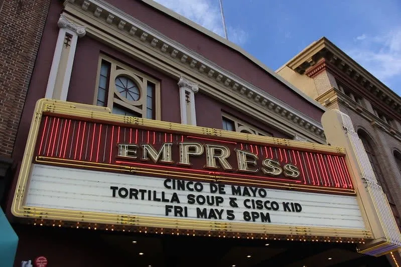 Theater marquee reading 'EMPRESS' with event text on the sign below.