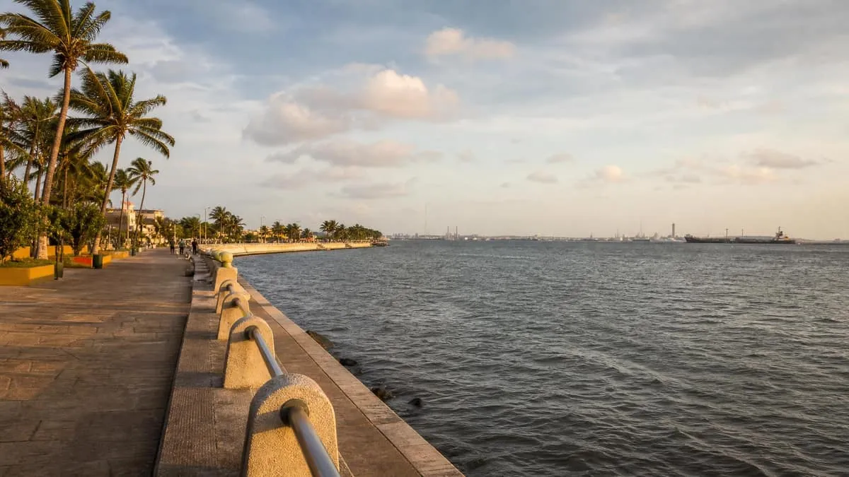 Coatzacoalcos malecon in December with Gulf water, palms, dry-season light, and holiday-season clouds