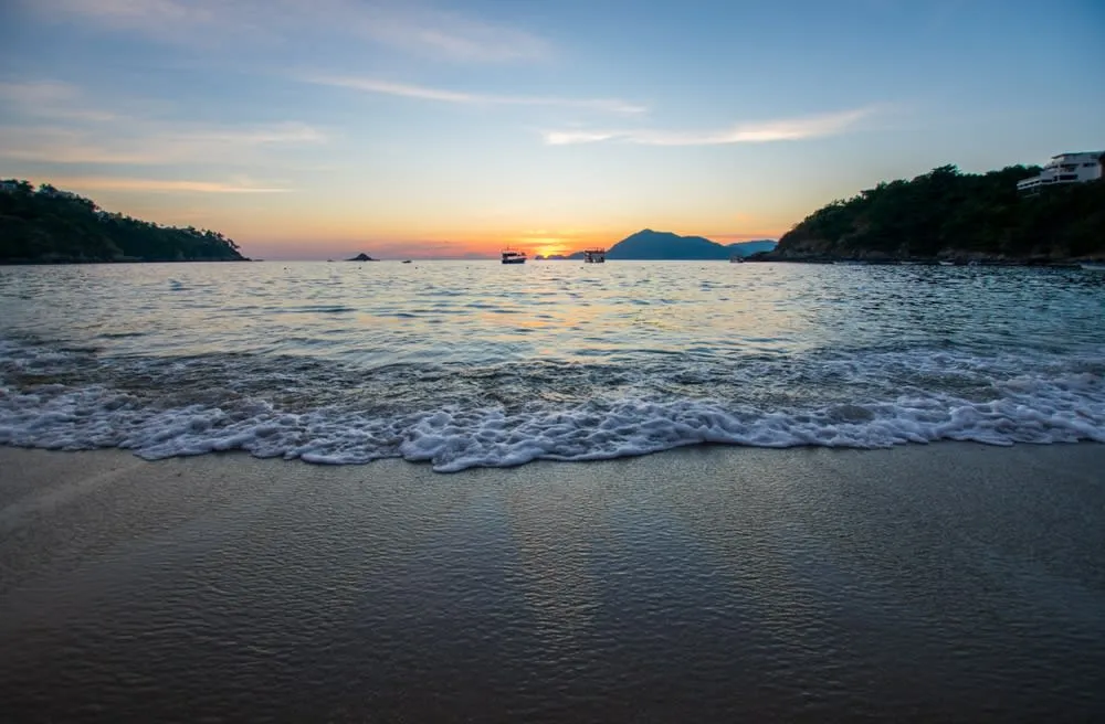 Volcán de Fuego Colima Mexico erupting with ash plume rising from the summit against blue sky