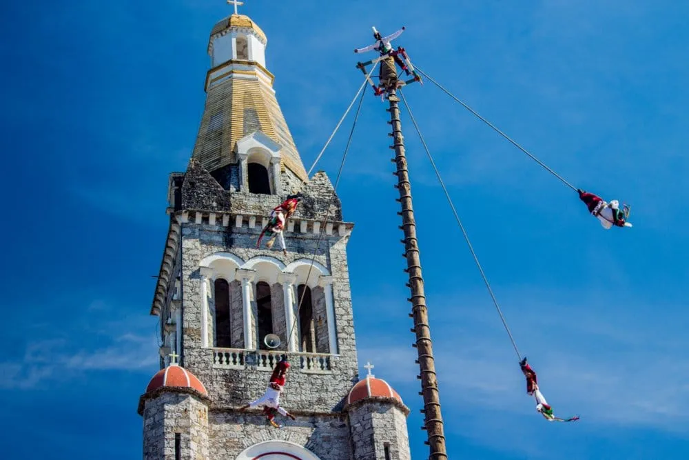 Cuetzalán Puebla mountain village with white colonial buildings and church tower emerging from cloud forest mist