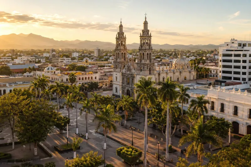 Palm-lined plaza in Culiacan with warm Sinaloa sunlight and city streets