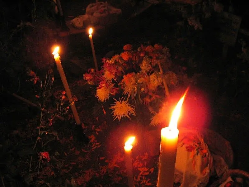 Candlelit Día de los Muertos cemetery vigil in Pátzcuaro, Michoacán — families keep watch through the night of November 1 as candles illuminate marigold-covered graves