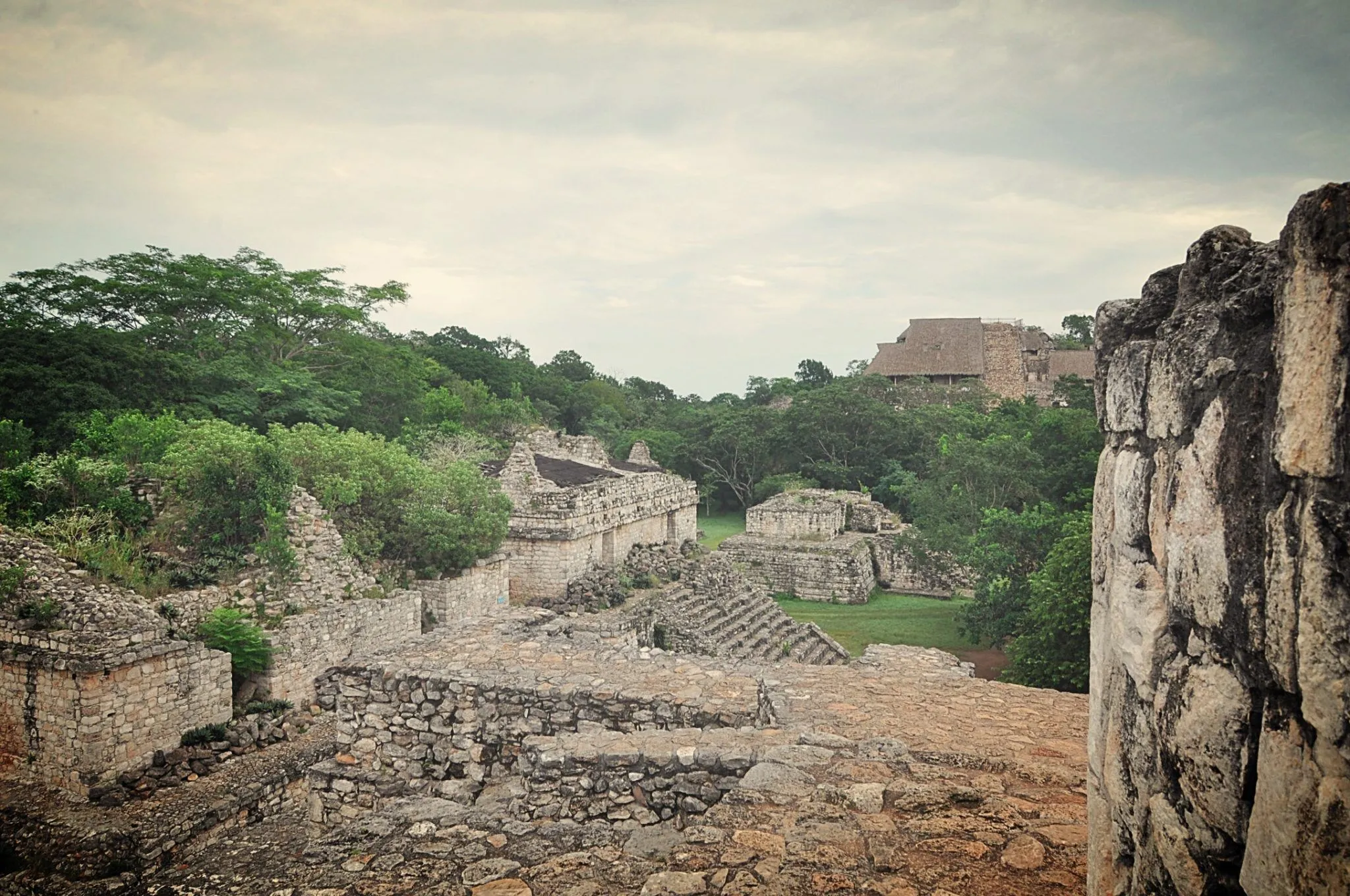 Ancient Maya ruins in the Yucatan jungle — stone temples with carved facades rising above tropical vegetation, similar to structures found throughout Quintana Roo