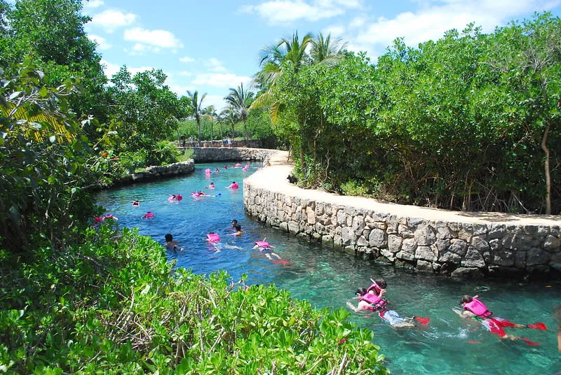 Turquoise inlet with wooden walkways, palms, and rocky edges