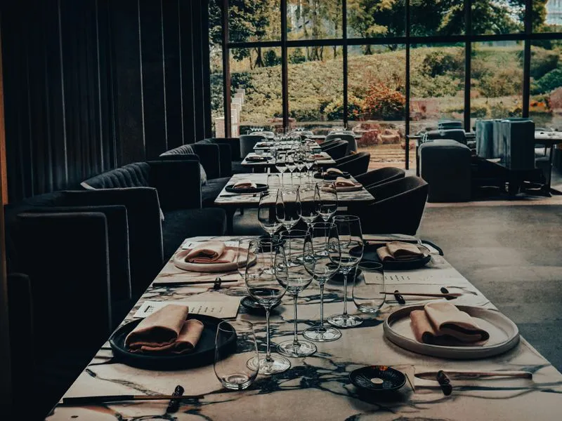 Elegant dining room in a Mexico City fine dining restaurant with modern Mexican design — white linen tables and contemporary Oaxacan-inspired art on the walls