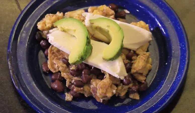Huevos a la Chiapaneca — fried eggs with corn tortilla strips, black beans, cream, and panela cheese