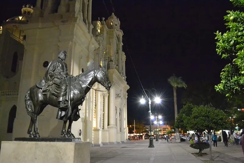 Equestrian statue and civic building in Hermosillo during a hot May Sonora evening