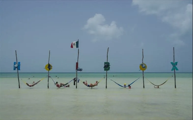 Overwater hammocks standing in the shallow blue sea at Holbox Island