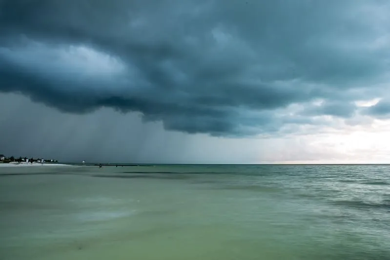 Rain clouds moving over the quiet beach and shallow water on Holbox Island