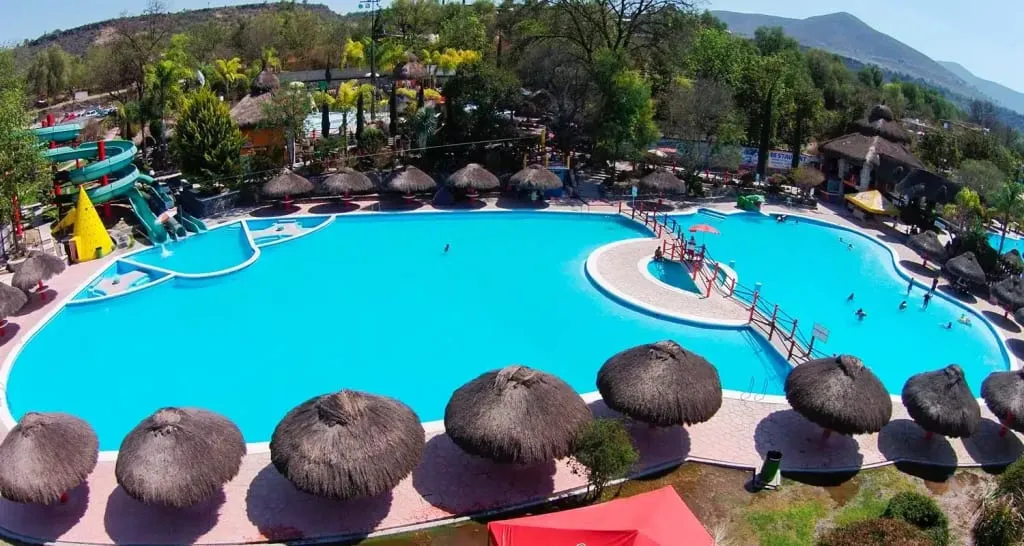 Tlaco Ecological Water Park thermal pools in Tlacotlapilco Hidalgo — 35-40 degree Celsius water with palapas and rain tree waterfall