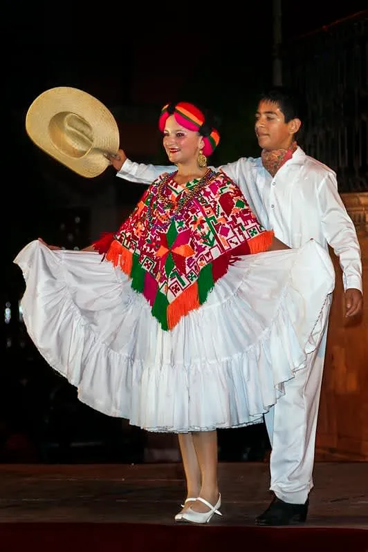 Huapango dance performers in traditional white embroidered costumes from the Huasteca region