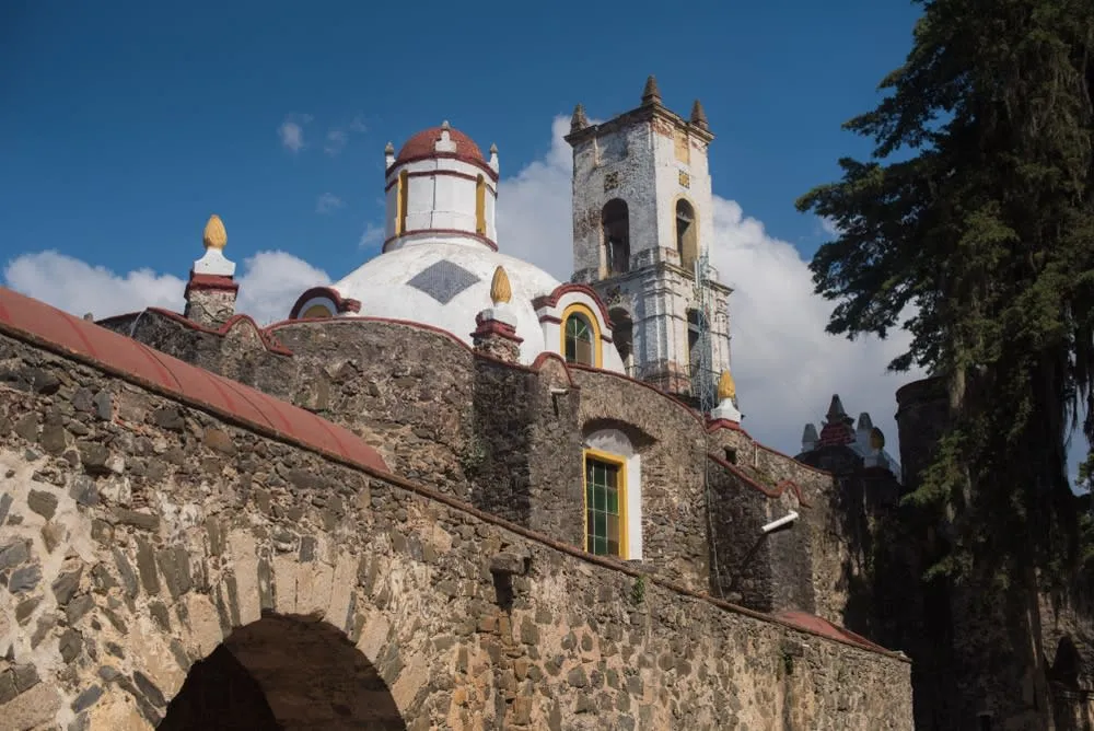 Historic stone buildings and trees in central Huasca