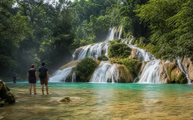 Turquoise waterfall pool in Huasteca Potosina surrounded by limestone cliffs and green forest