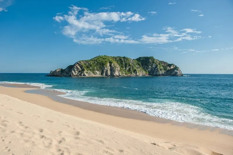 Calm turquoise water beside white resort towers on Huatulco's Oaxaca coast