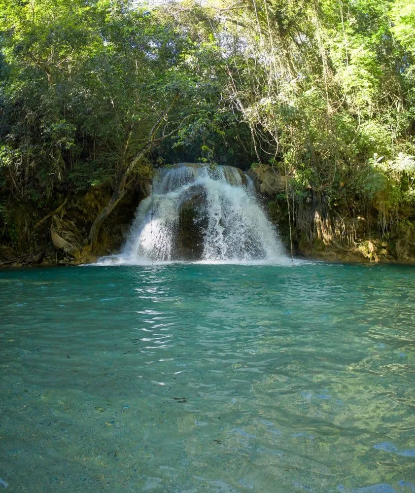 Copalitilla waterfall near Huatulco with hikers on a trail through lush Oaxacan jungle vegetation
