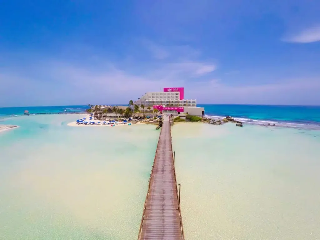 Mia Reef hotel buildings on a small islet beside the clear water at Playa Norte