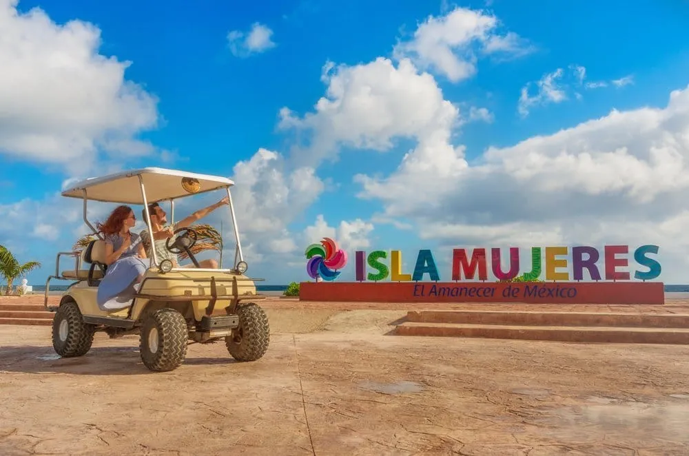 Golf carts lined up for rent on a narrow Isla Mujeres street