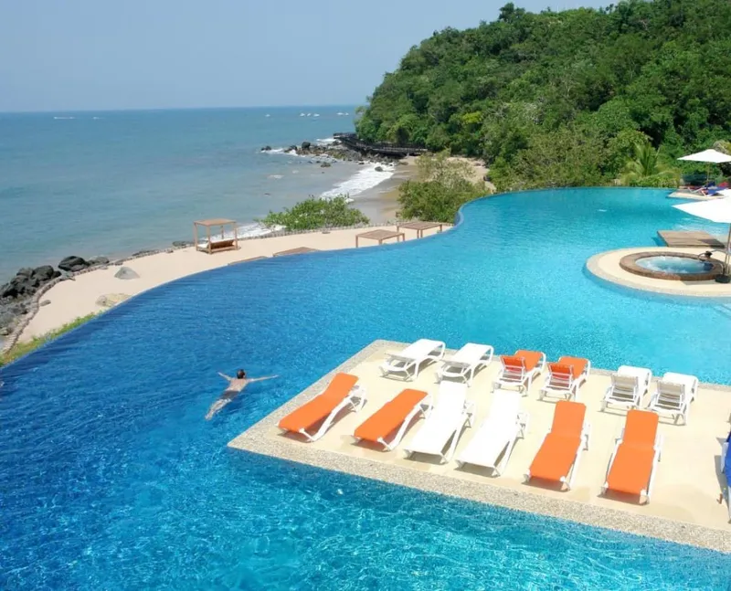 Hotel pool decks and beachfront towers beside a wide sandy beach