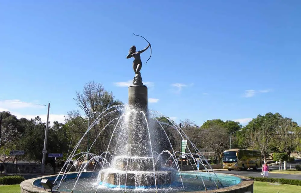 Diana the Huntress statue on Ixtapan de la Sal boulevard framed by jacaranda trees