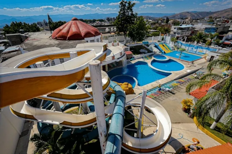 Families swimming and riding slides at the Ixtapan Water Park complex