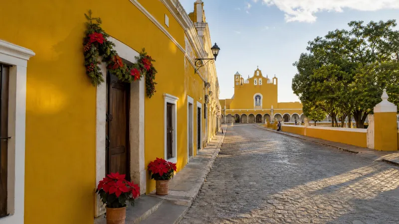 Yellow colonial street in Izamal with December dry-season light and poinsettias