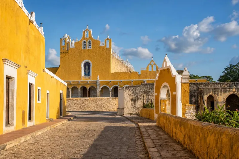 Yellow colonial buildings and the San Antonio convent area in Izamal during hot May weather