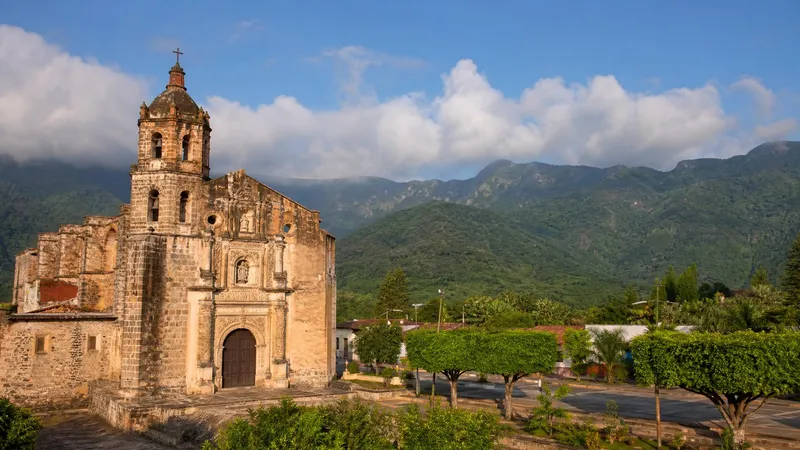 Jalpan de Serra mission in July with green Sierra Gorda hills, morning light, and summer clouds