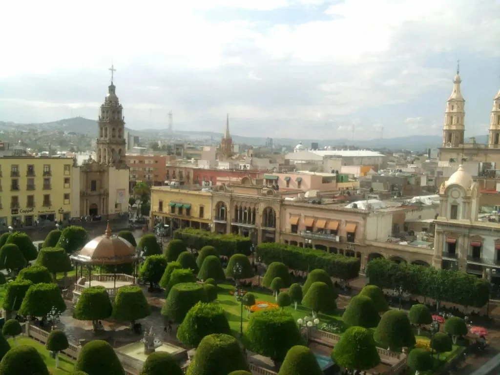 Fountain and trimmed trees in Plaza de los Fundadores