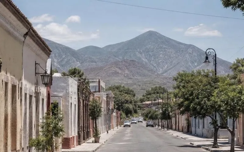 Clear December street near Linares historic center with Nuevo Leon foothills beyond the rooftops